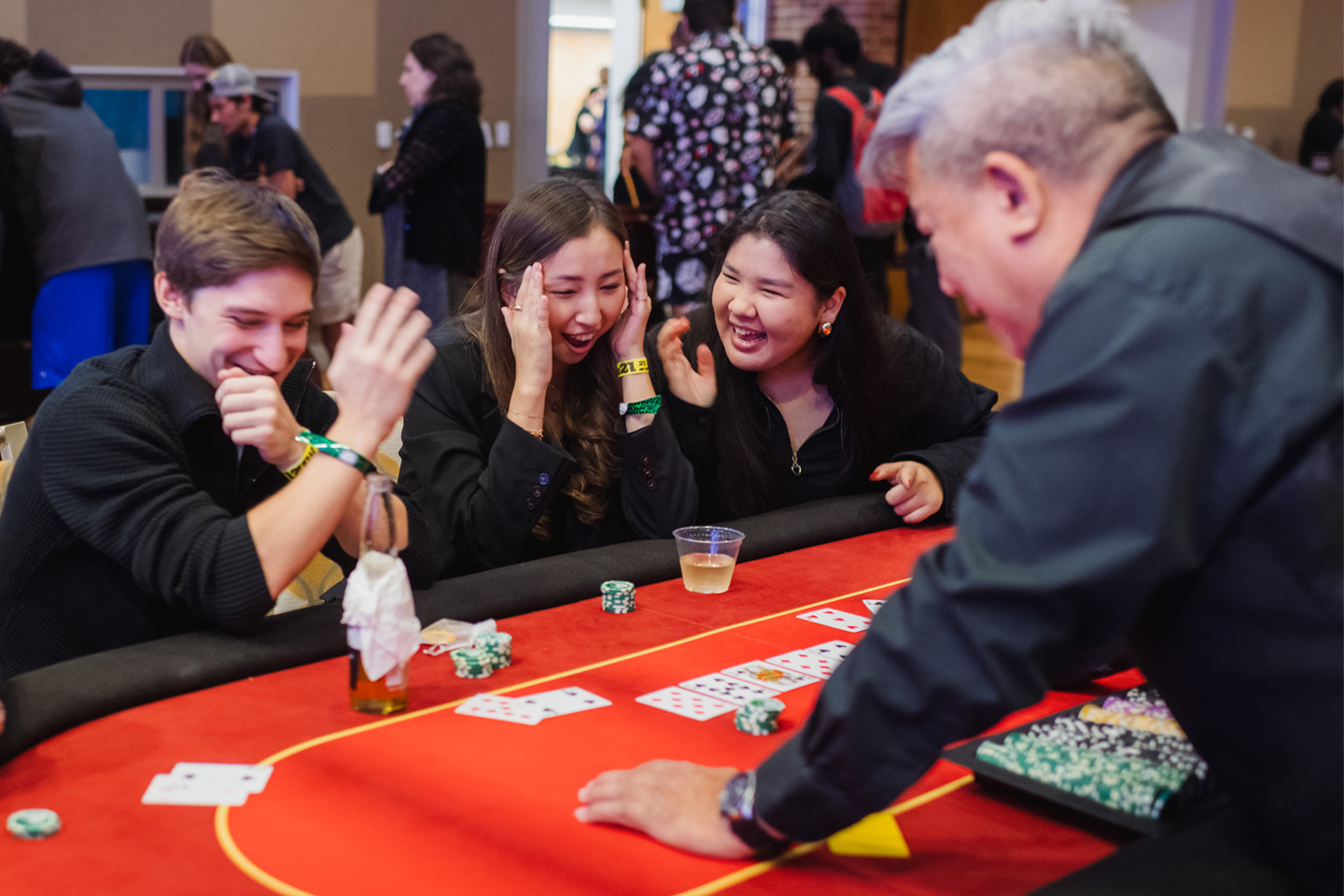 Three women at a casino table share their excitement.