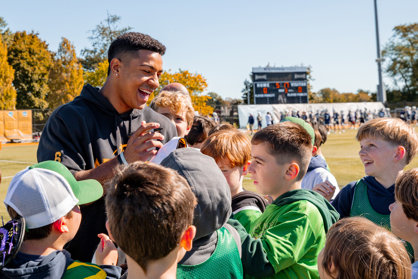 A tall athlete is surrounded by young fans.