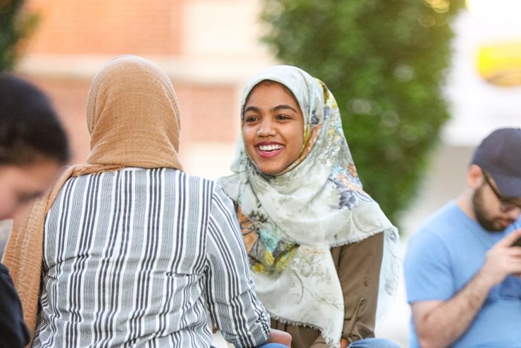 Two students wearing a religious head scarf speak on campus. 