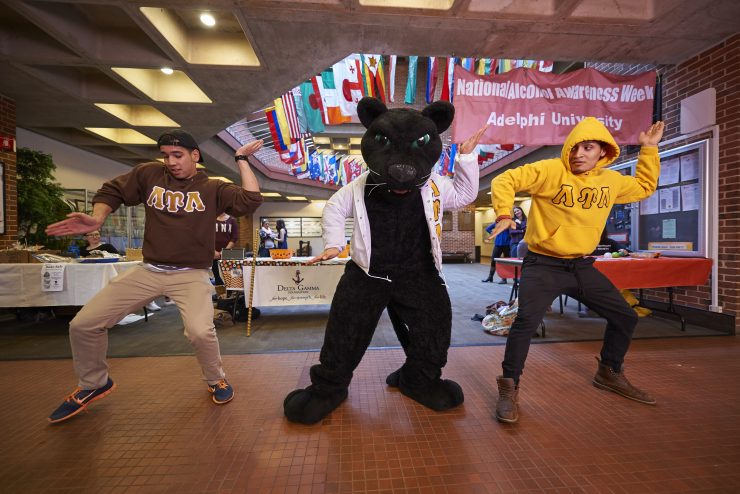 Students dancing with the Adelphi Panther mascot