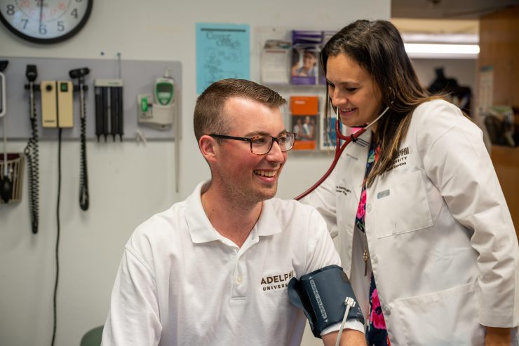 Adelphi health services practitioner with a student patient.