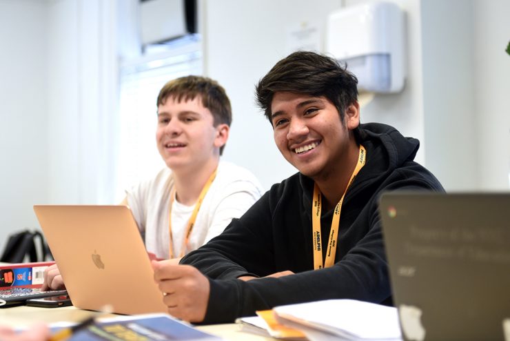 High school students smiling in a pre-college class