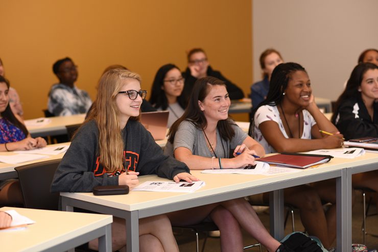 high school students at Adelphi in classroom smiling