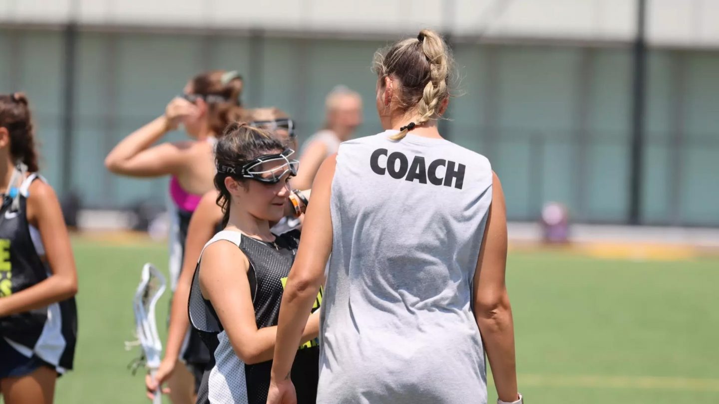 Adelphi University Summer Camp: Lacrosse coach works with kids on campus fields.