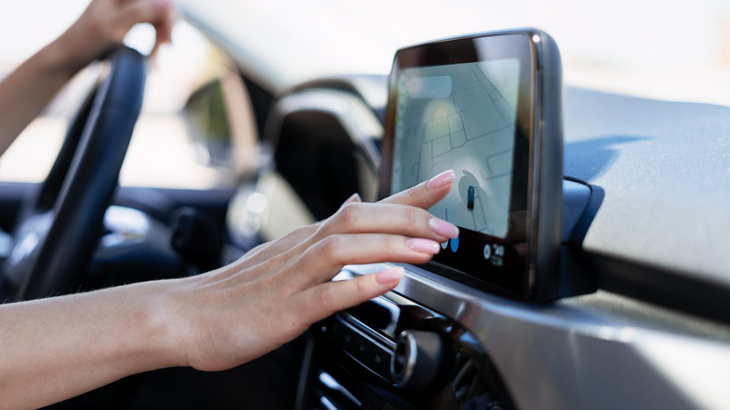 Woman's hand tapping the GPS map in her car. Directions