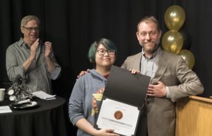 Student Jessica Cooper receives an award from the Communications Department.