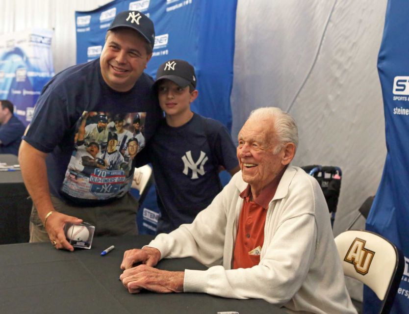 Michael DeMiro Jr. with his son Michael III and Don Larson as he signs autographs. Photo credit: Newsday