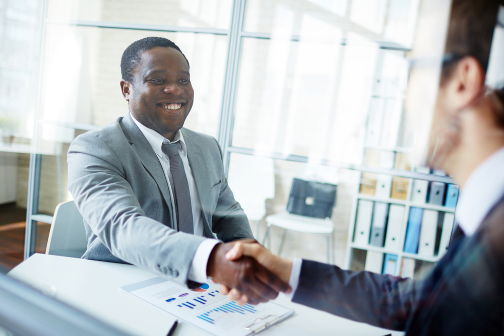 African American and Caucasian professionals shaking hands