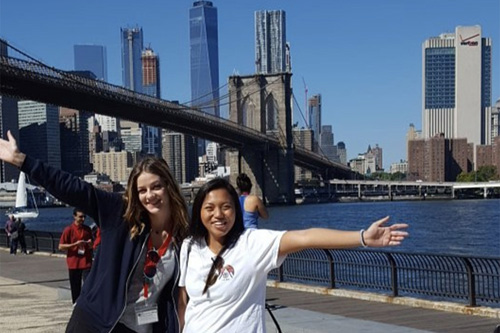 Two Adelphi students in Manhattan with the Brooklyn Bridge in the background.