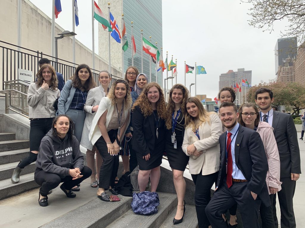 National Model United Nations group photo outside in front of flags