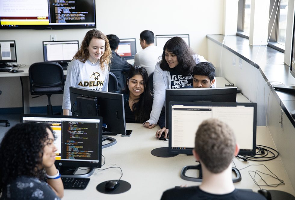 Adelphi University computer science classroom: students learning at monitors