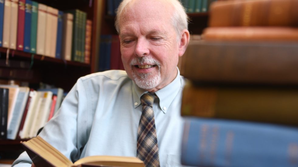 Richard Garner, PhD reading a book in his office