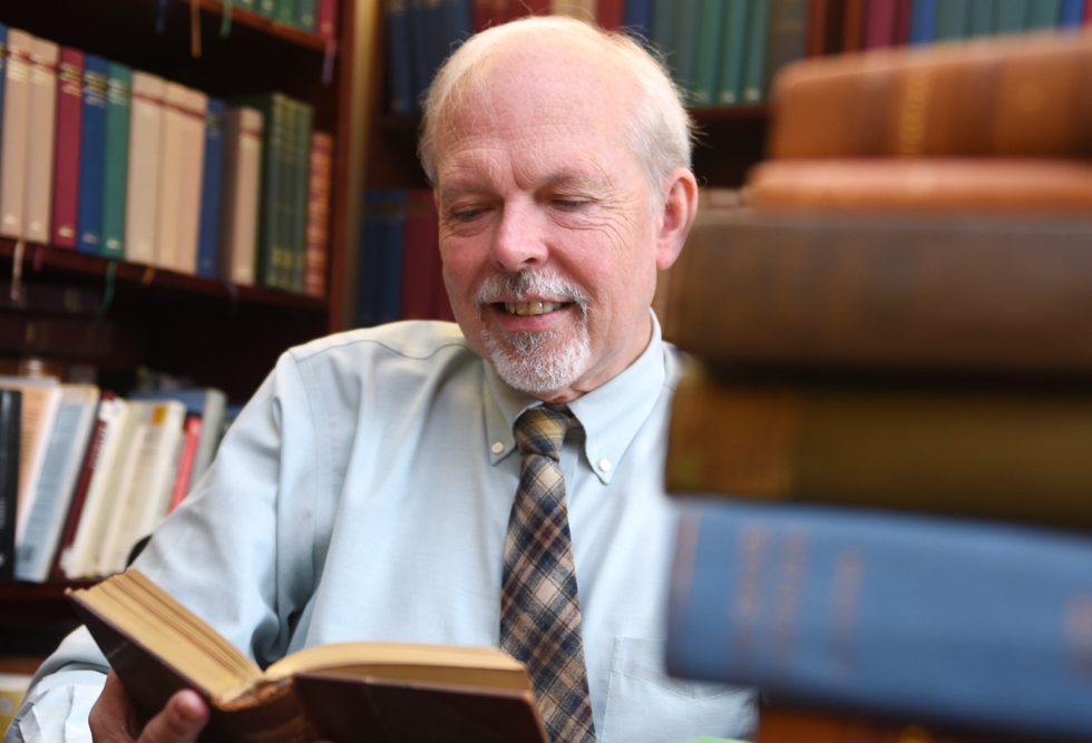 Richard Garner, PhD reading a book in his office