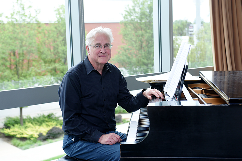 Professor of Music Paul Moravec seated at a piano.