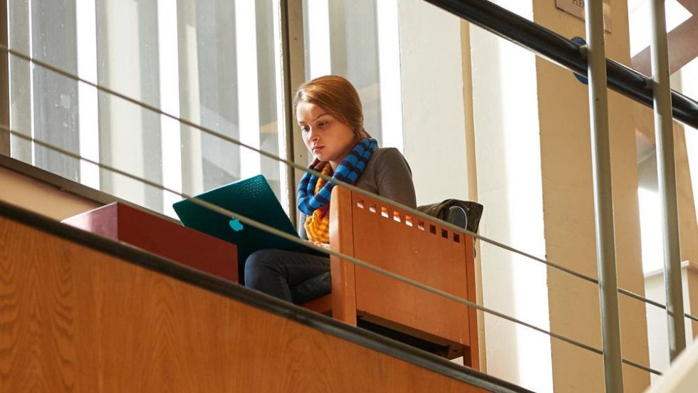 A student in the Swirbul Library using a laptop.