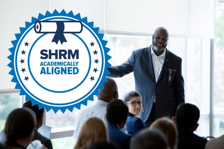 SHRM Seal overlaid over a photograph of an HR professional leading a training session with employees