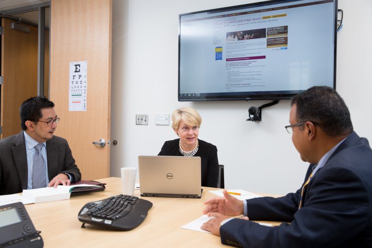 Healthcare administrators around a table discussing strategy