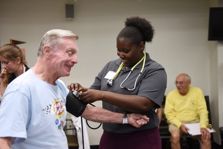 Senior citizen getting their blood pressure checked by a staff member during Adult Fitness.