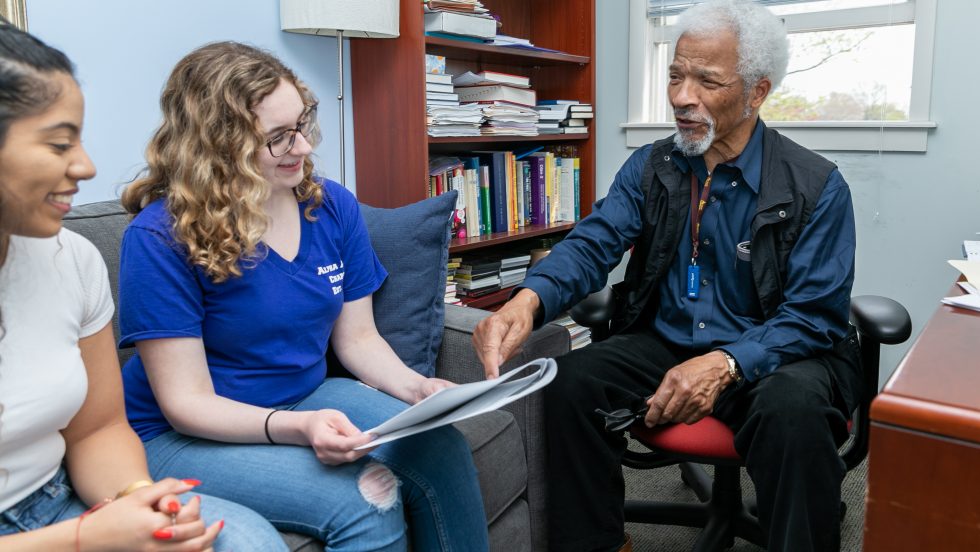 An Adelphi professor meeting with students.