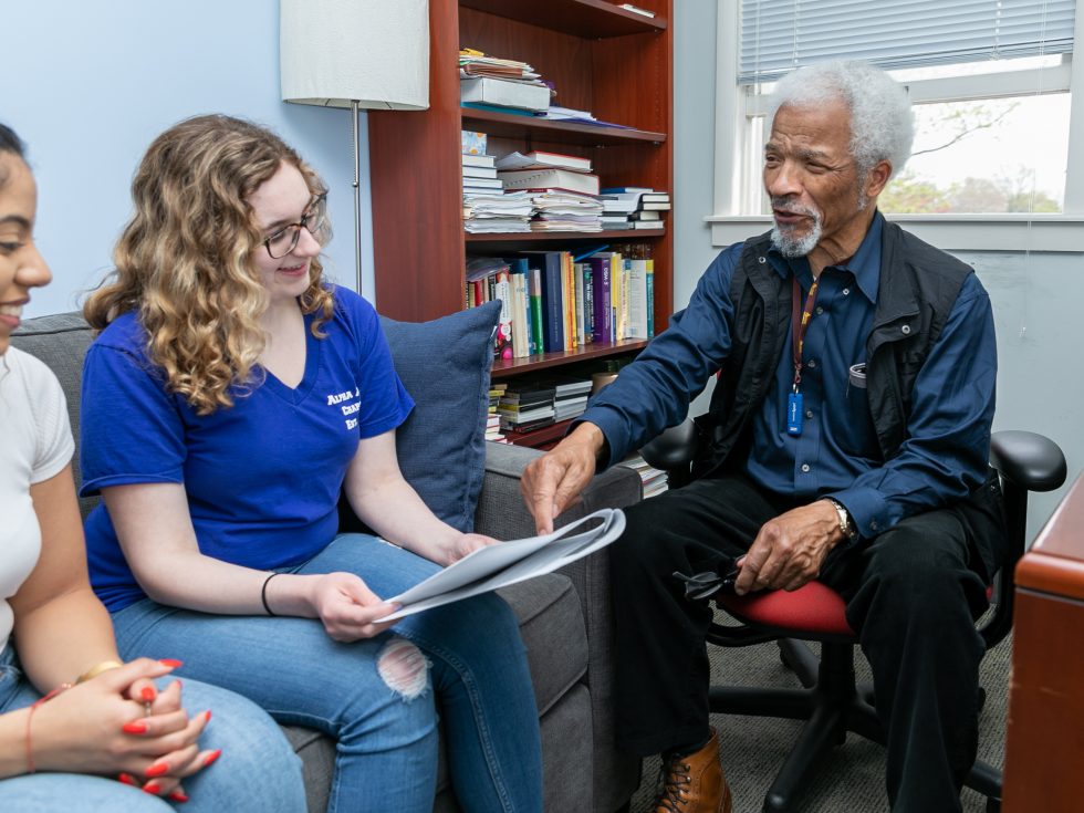 An Adelphi professor meeting with students.