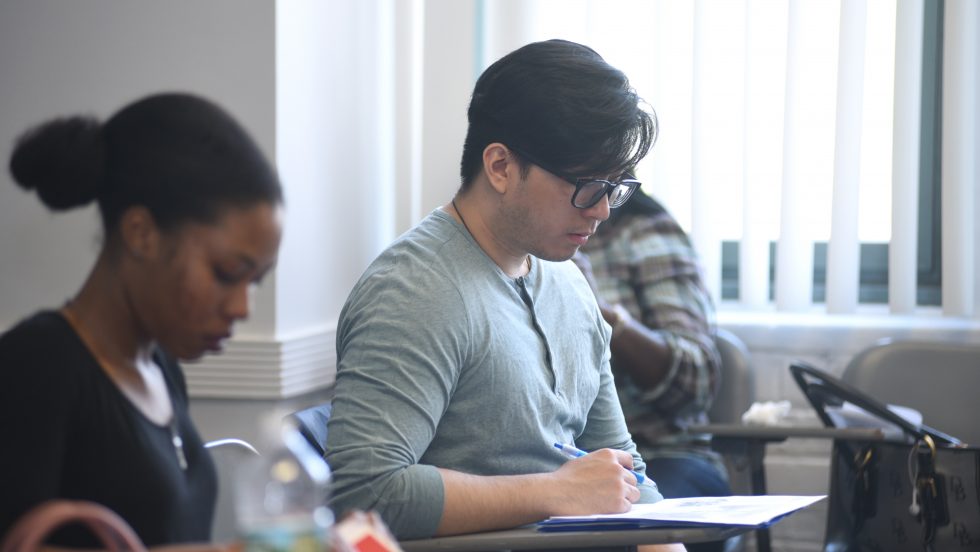 Adelphi social work programs: students studying and writing notes in class