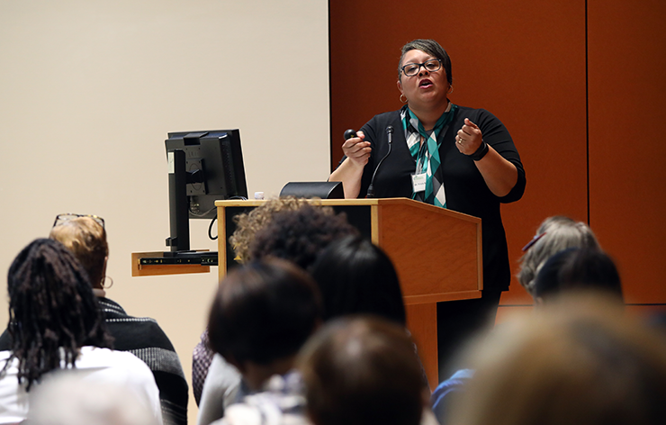 A woman speaking passionately at a podium on a community health issue.