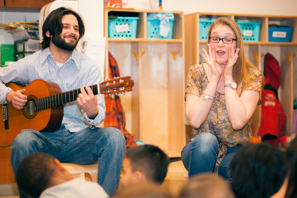 Instructors play music and sing to a classroom of young children.