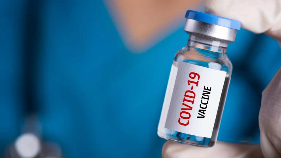 Person holding a cOVID-19 vaccine vial