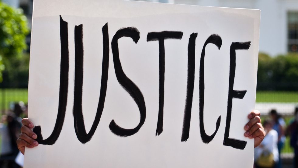 A protest sign that states the word "Justice" boldly.