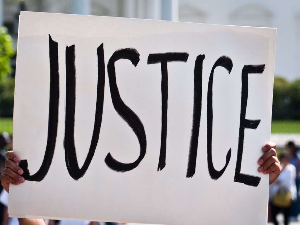 A protest sign that states the word "Justice" boldly.