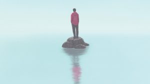 A photo of a person standing on a small patch of land with foggy water surrounding.