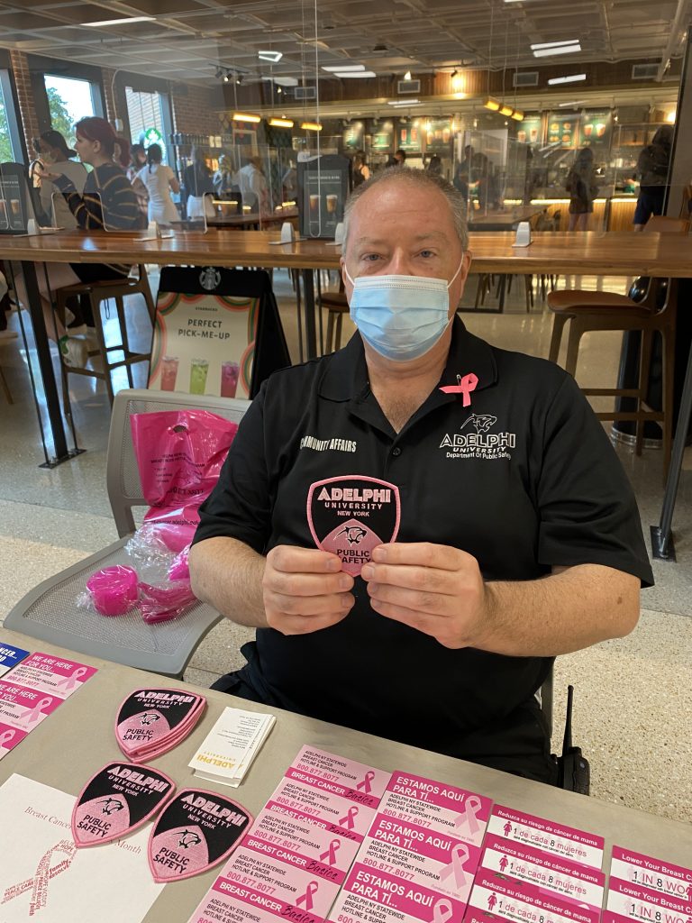 Sergeant Gerry Lennon of Adelphi's Department of Public Safety and Transportation holding a Pink Patch for Breast Cancer Awareness.