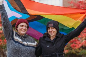 Two students holding a pride flag