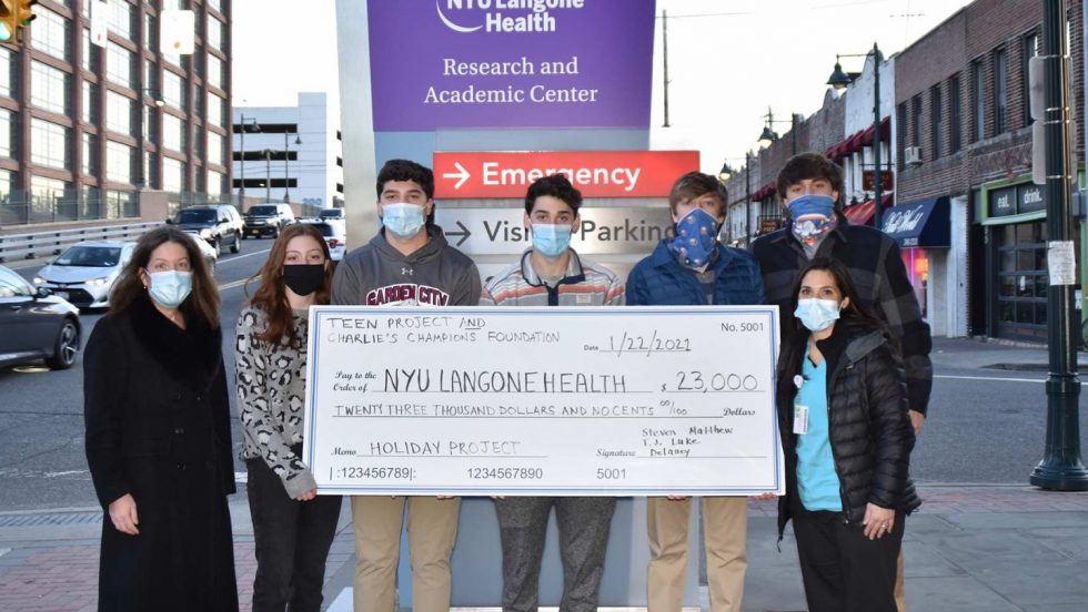 Matthew Spirakis and volunteers holding a large check.