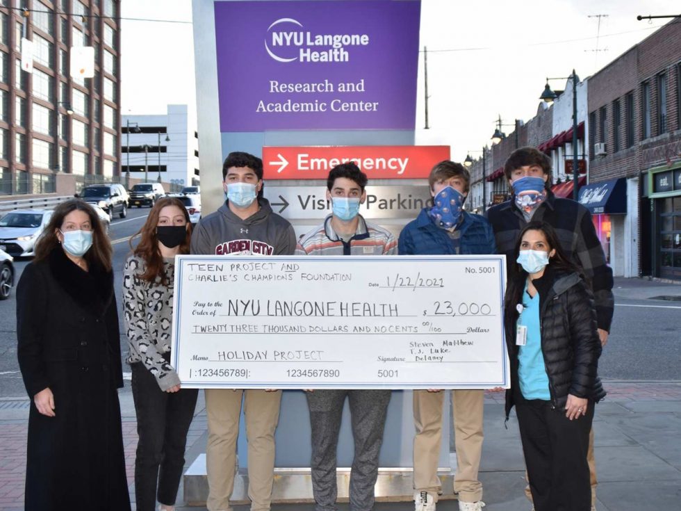 Matthew Spirakis and volunteers holding a large check.