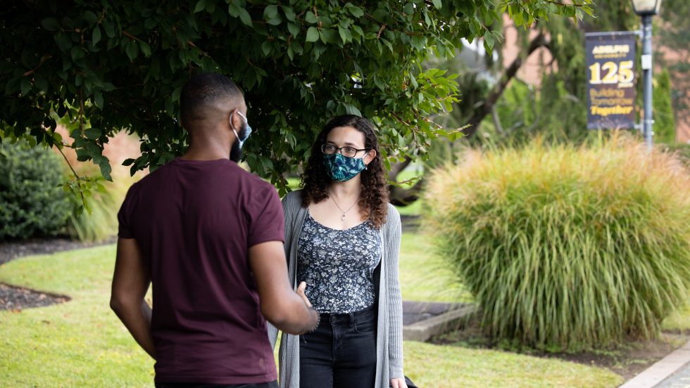 Adelphi students wearing masks and talking.