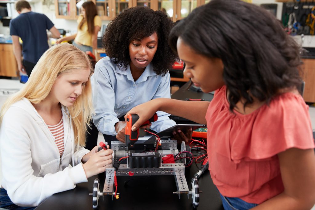 Three female students working in robotics.