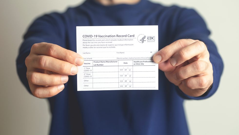 Someone holding a COVID-19 vaccination card