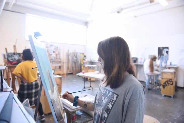 An art student painting in the Klapper arts facility at Adelphi