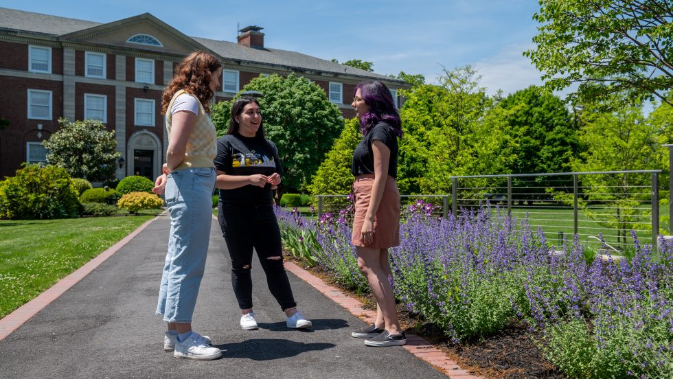 Students talking in front of the Levermore Hall building at Adelphi University