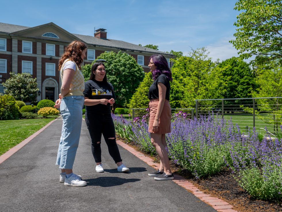 Students talking in front of the Levermore Hall building at Adelphi University