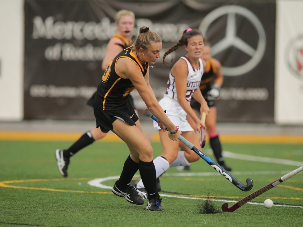 Jacklyn Brown and players on the field hockey field.