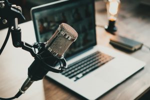 Podcasting microphone with laptop on a desk