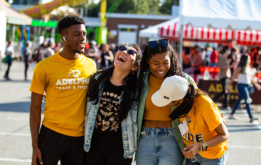 Adelphi students laughing together at the Panther Carnival during Adelphi University Spirit Weekend