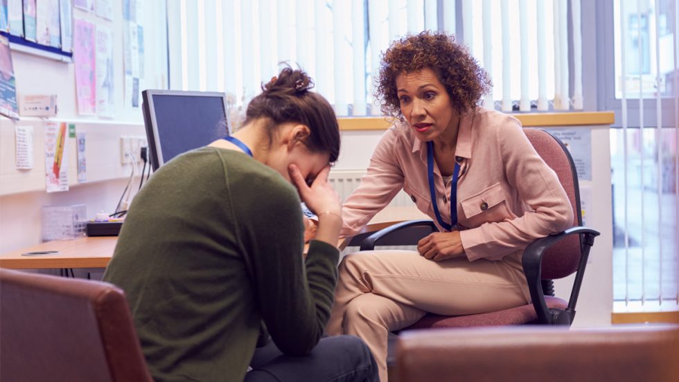 Mental Health Counselor comforts a distressed woman in an office
