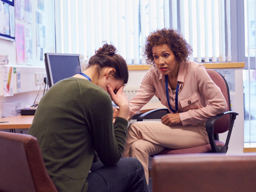 Mental Health Counselor comforts a distressed woman in an office