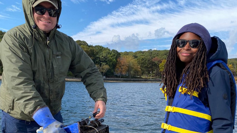 Two people on a boat on the Cold Spring Harbor wearing life vests