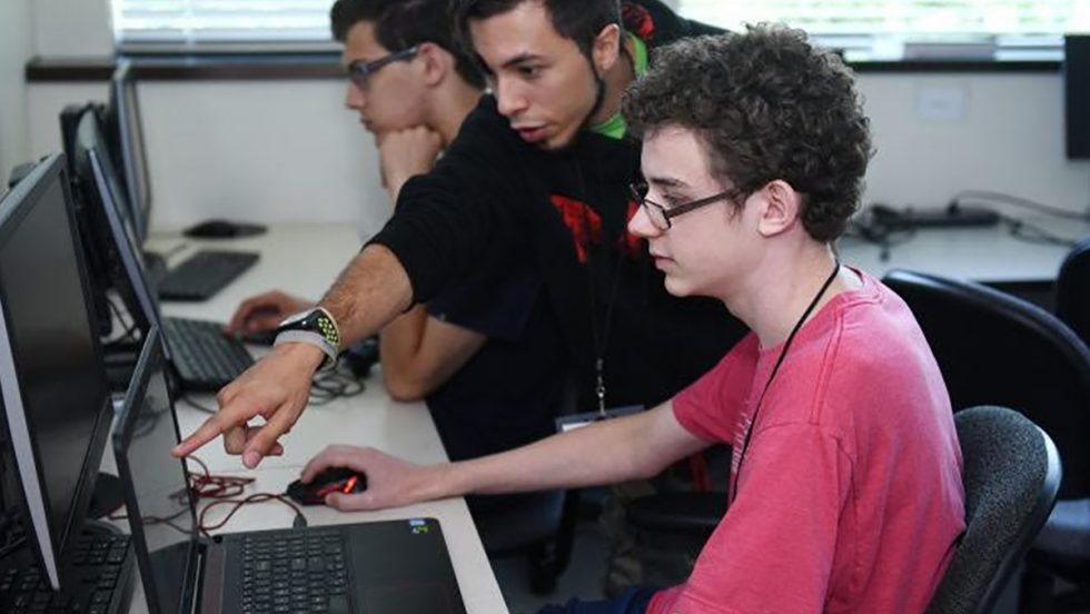 Three Adelphi students at computers