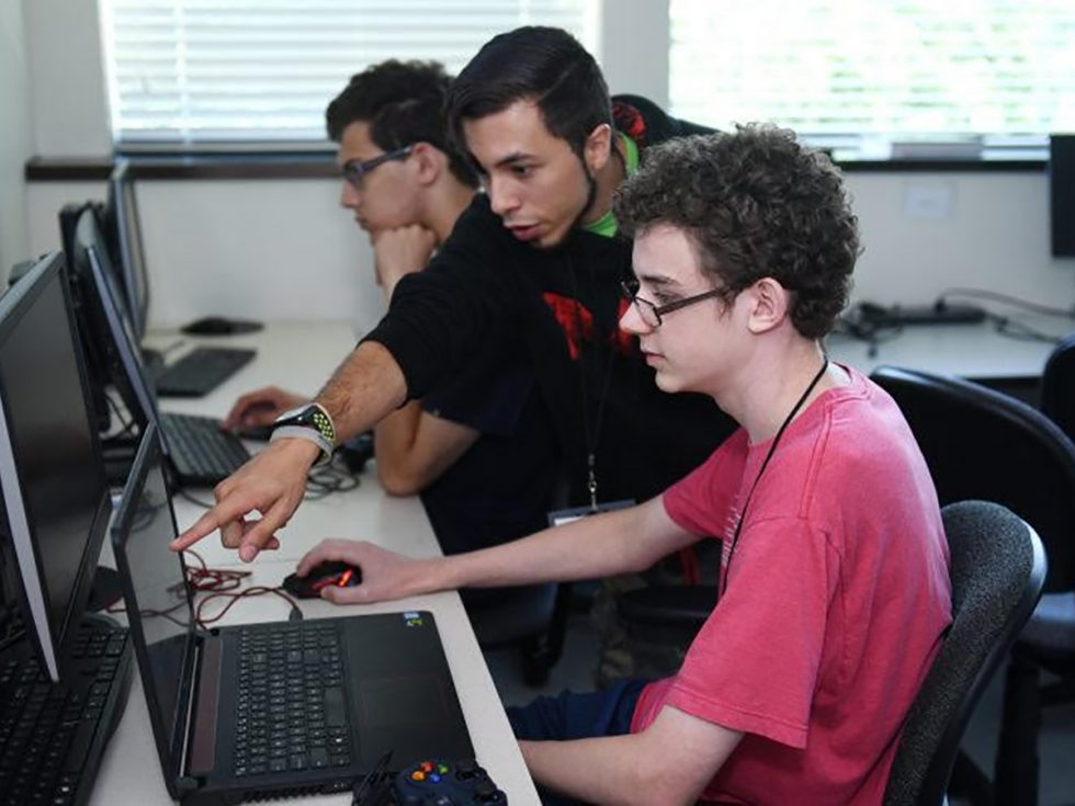 Three Adelphi students at computers