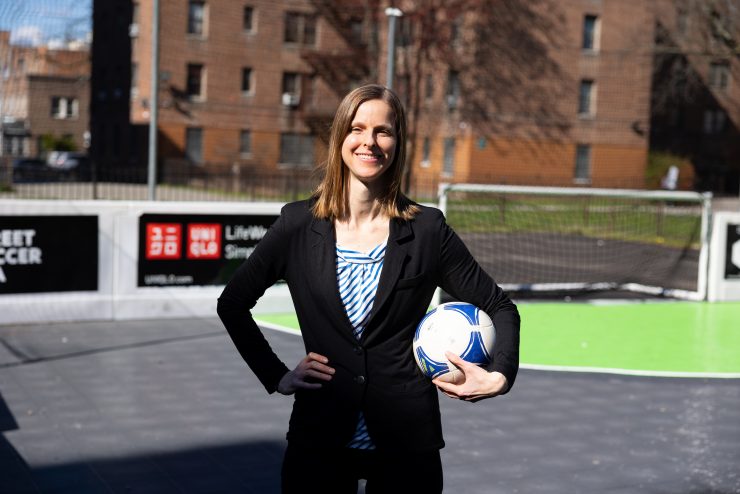 Meredith Whitley on a soccer court holding a soccer ball.